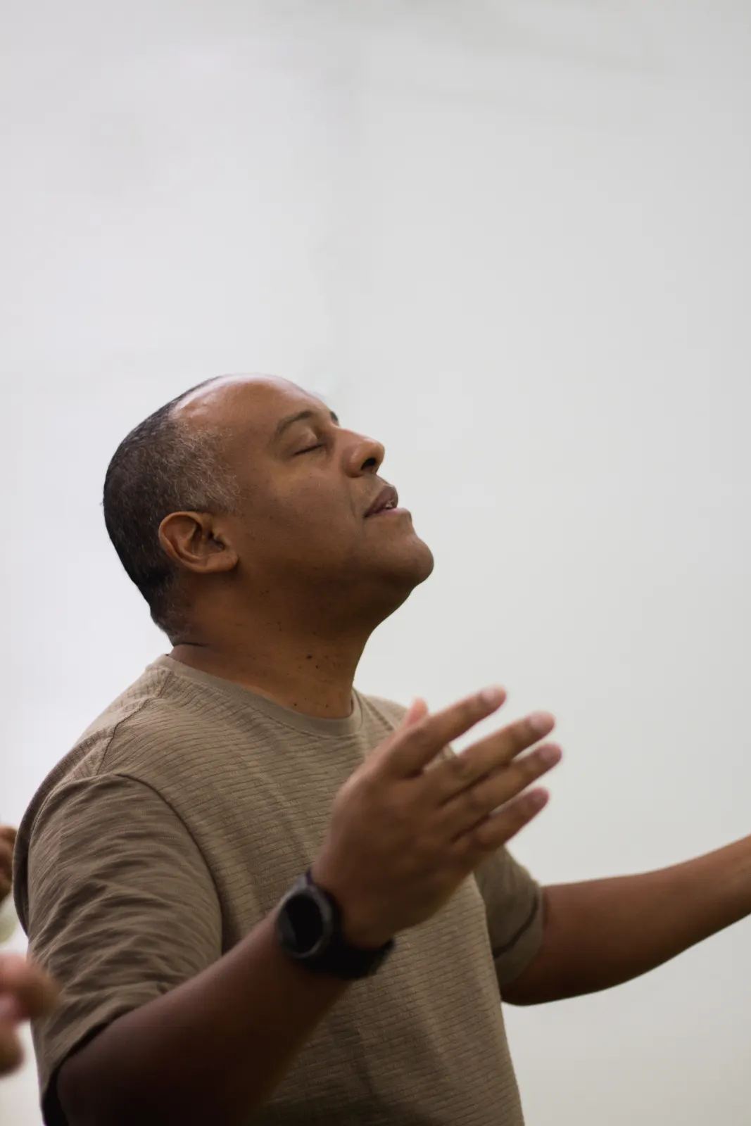 Homem de braços abertos durante um momento de louvor.